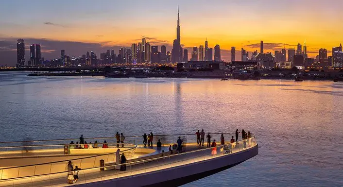 Photograph of The Viewing Point, a curved deck over the creek, with the Downtown Dubai skyline at sunset